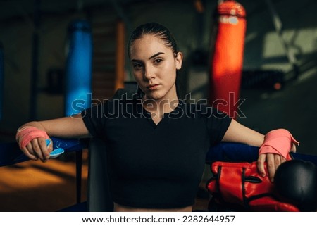 Portrait of a young female fighter in the corner of the ring