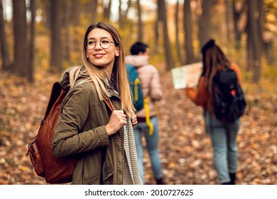 Portrait of young female hiker in forest with friends. - Powered by Shutterstock