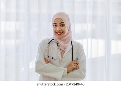 Portrait Of Young Female Muslim Asian Doctor Holding Up Medical Syringe For Giving Injection Of Vaccine And Smile.