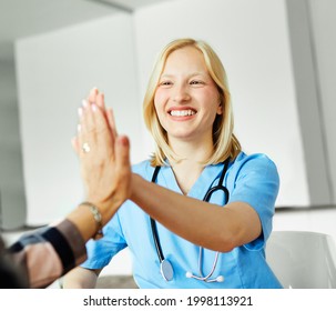 Portrait Of A Young Female Nurse Givinh High Five To Patient
