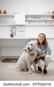 A Portrait Of Young Female Owner With Big White Dog Waiting For The Veterinarian In Veterinary Clinic. Pet Care Concept