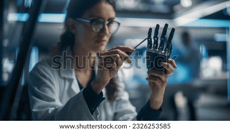 Portrait of Young Female Scientist Working in Technological Research and Development Company, Assembling an Innovative Bionic Prosthetic Hand. Engineer Working on Technology for Physically Impaired