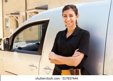 Portrait Of Young Female Trade Worker Standing By A Van