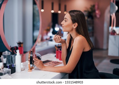 Portrait of young female worker near the table in beauty salon.