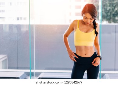 Portrait Of Young Fit Asian Woman Standing In Gym, Hands On Hips Pose. Fitness Female Model Image