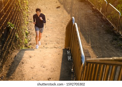 Portrait Of Young Fitness Runner Woman Training Herself By Running Up Steps On Staircase In Urban Street. Uphill Running Can Improve Average Running Speed And Your Step Length Greater Benefit.