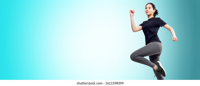 Portrait Of Young Fitness Woman In Sportswear Jumping. Copy Space. Over Blue Background.