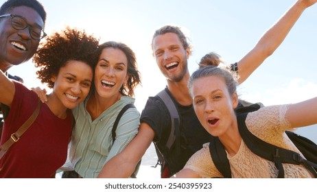 Portrait Of Young Friends With Backpacks Hiking In Countryside Looking Down Into Camera - Powered by Shutterstock