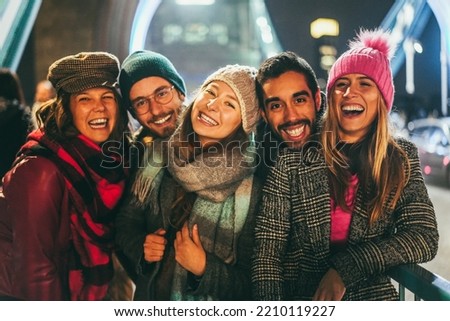 Portrait of young friends having fun outdoor with London Tower Bridge in background - Soft focus on center girl face.