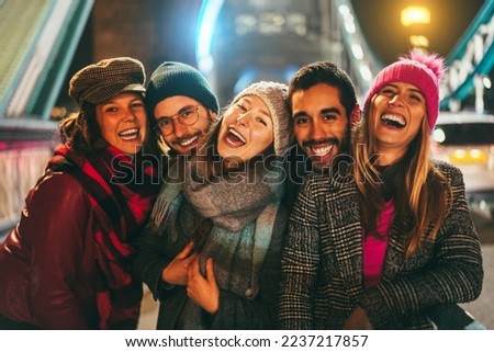 Portrait of young friends having fun outdoor with London Tower Bridge in background - Soft focus on center girl face