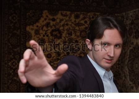 Portrait of a young funny man in jacket indoors