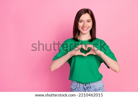 Portrait of young funny smiling attractive girl showing heart lovely have feelings isolated on pink color background