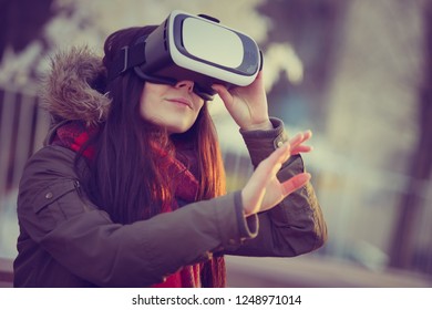 Portrait Of Young Gamer Girl Playing Vr Game Outside In Winter Day