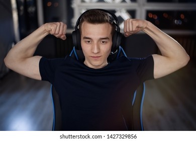 Portrait Of Young Gamer Guy In Headphones Screaming And Rejoicing Unleash Power While Playing Video Games On Computer Young Man Shows His Biceps