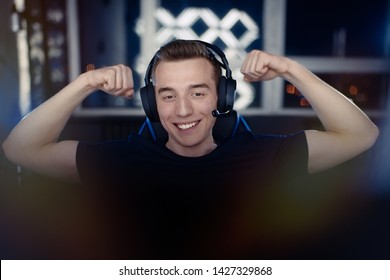 Portrait Of Young Gamer Guy In Headphones Screaming And Rejoicing Unleash Power While Playing Video Games On Computer Young Man Shows His Biceps