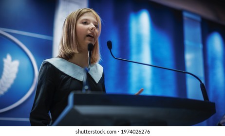 Portrait Of An Young Girl Activist Delivering An Emotional And Powerful Speech At A Press Conference In Government Building. Child Speaking To Congress At Summit Meeting With World Leaders.