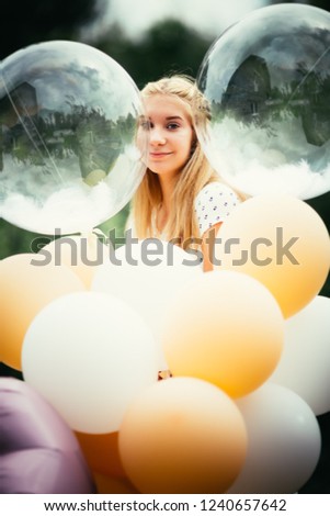 portrait of young girl with balloons on nature background.