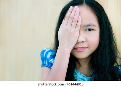 Portrait Of A Young Girl Covering Face With Hands, Close One Eye