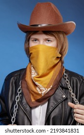 Portrait Of A Young Girl In A Cowboy Hat, With A Handkerchief Covering Her Airways And An Iron Chain Around Her Neck