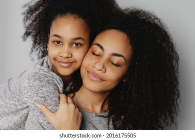 Porträt eines jungen Mädchens, das Mutter von hinten umarmt.