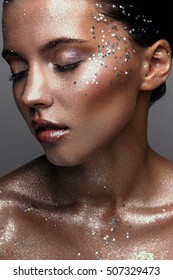 Portrait of a young girl with fashion bronze glitter makeup with sequins