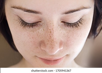 Portrait of a young girl with freckles without makeup.