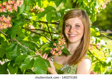 Portrait of young girl holding blossom in sunny park spring - Shutterstock ID 140375185
