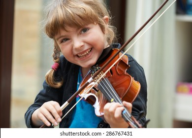 Portrait Of Young Girl Learning To Play Violin