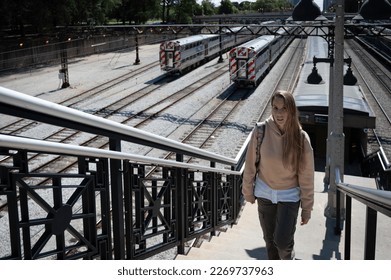 Portrait of a young girl in long hair blonde with sweatshirt walking up the stairs of the Chicago train station - Powered by Shutterstock