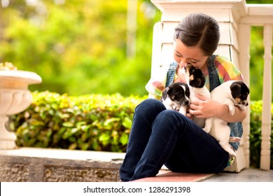 Portrait Of Young Girl On Front Stoop With A Litter Of Puppies.