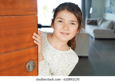 Portrait Of Young Girl Opening Front Door Of The House