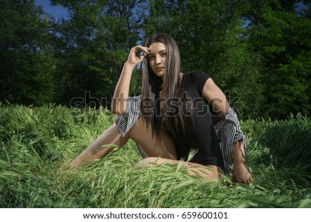 Portrait of a young girl posing in a grass field 
