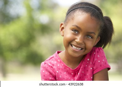 Portrait Of Young Girl Sitting In Park