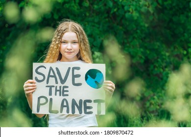 portrait of young girl standing with Save the planet Poster on school backyard. piles of plastic garbage on ground. teen kid child volunteer protest against earth pollution, global warming, recycle.