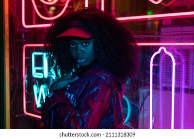 portrait of a young girl in sunglasses and with in the night city, with creative light on the background of neon lamps. Night clubs, parties, night life