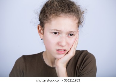 Portrait Of A Young Girl With Toothache Over White Background.Child Toothache With Sensitive Tooth Ache Problem Touching On Face The Part With Pain.