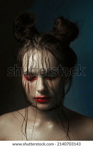Portrait of a young girl with wet facial hair and dirty wet makeup. Mental health concept, close-up on a colored background, hairstyle with two buns