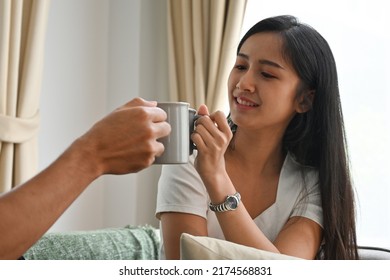 Portrait with Young girlfriend clink a mug with her boyfriend, Domestic life and Domestic home concept.