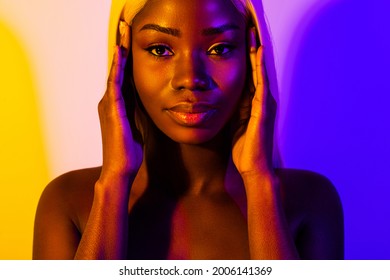 Portrait of young gorgeous flawless sensual afro woman hold hands face wear no clothes isolated on colorful background