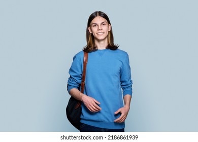 Portrait Of Young Guy With Backpack On Gray Background