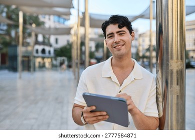 Portrait of a young guy man using tablet in the street