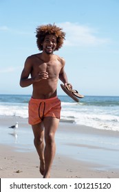 portrait of a young handsome African American jogging on the beach