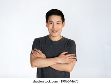 Portrait of a young and handsome Asian man folding arms with self-confident posing.