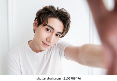 Portrait of young handsome asian man use smartphone selfie say hi over white background. Happy asian guy online influencer blogger. Education technology connected people man lifestyle concept