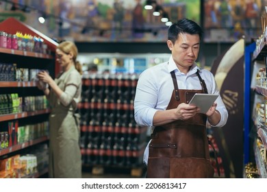 Portrait Of A Young Handsome Asian Man, Shop Owner, A Supermarket Worker