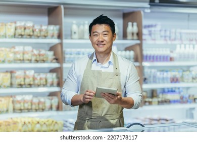 Portrait Of A Young Handsome Asian Man, Shop Owner, A Supermarket Worker