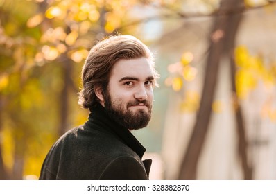 Portrait Of Young Handsome Bearded Guy, Looking Back, In The Autumn City Park.