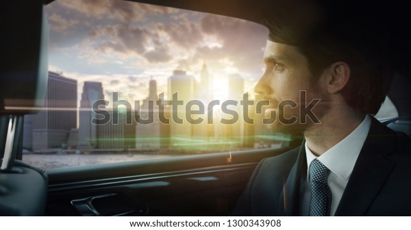 Portrait of young handsome businessman\
traveling in a modern car with a driver in center of the city by\
day. Concept of business, success, traveling, luxury\
