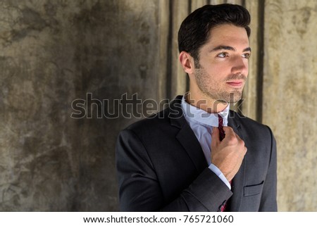 Portrait of young handsome businessman wearing suit exploring the city of Bangkok Thailand