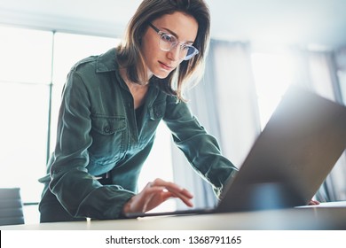 Ritratto di giovane donna d'affari bello utilizzando computer portatile in ufficio moderno.Sfondo sfocato